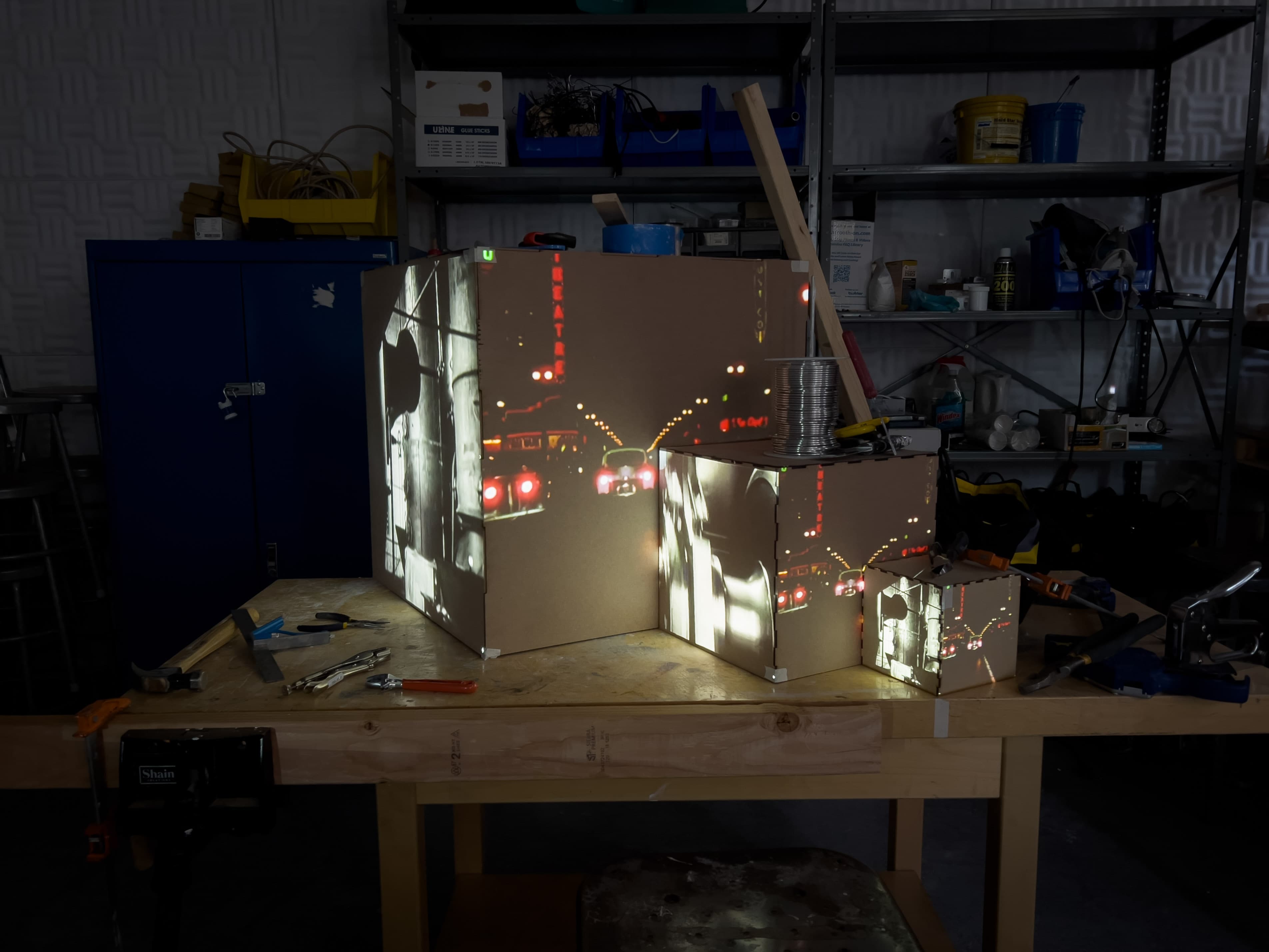 Video of a car driving at night projected onto the three cardboard cubes