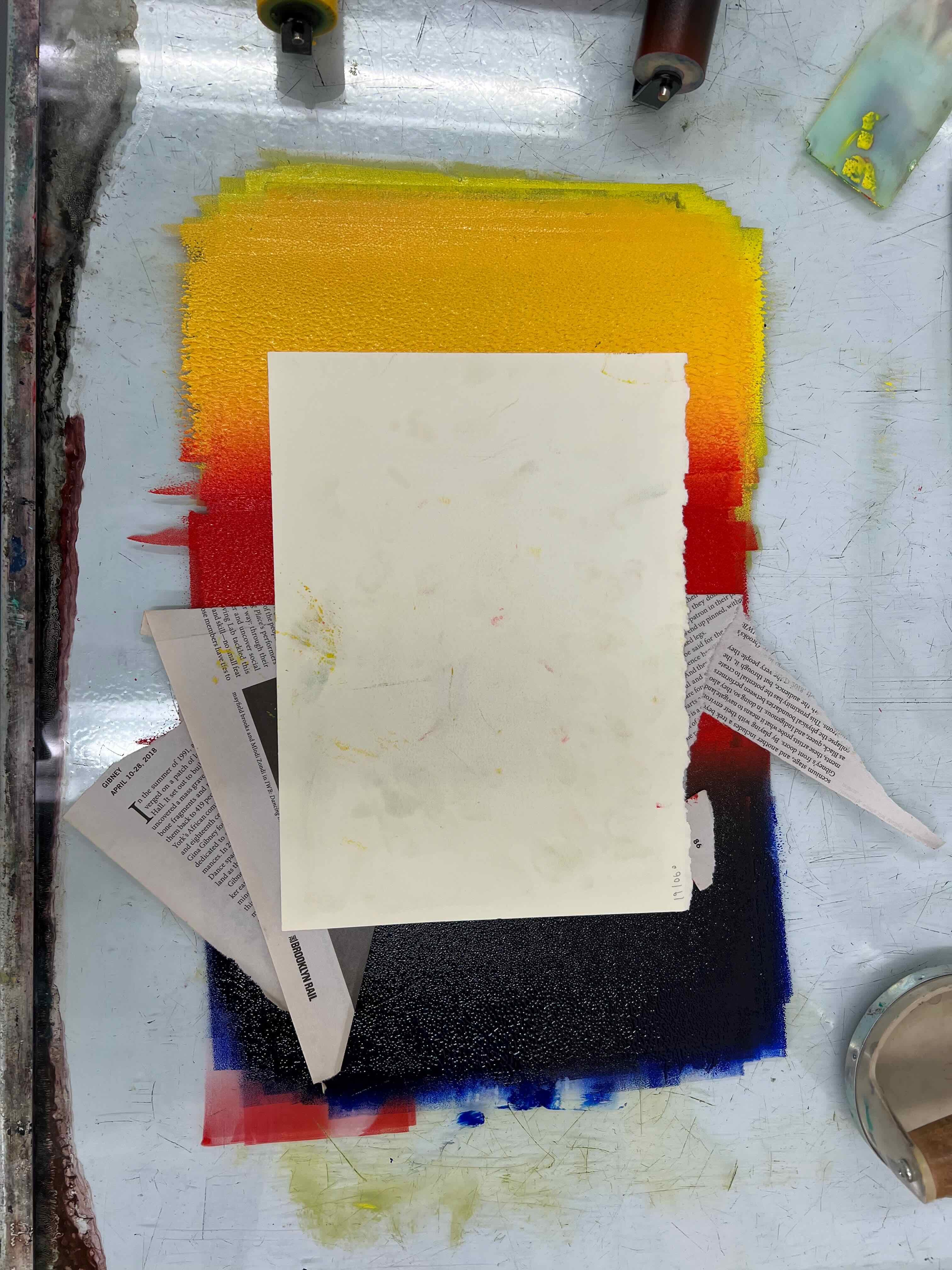 An in progress monoprint print side down in the ink, blocked by newsprint
